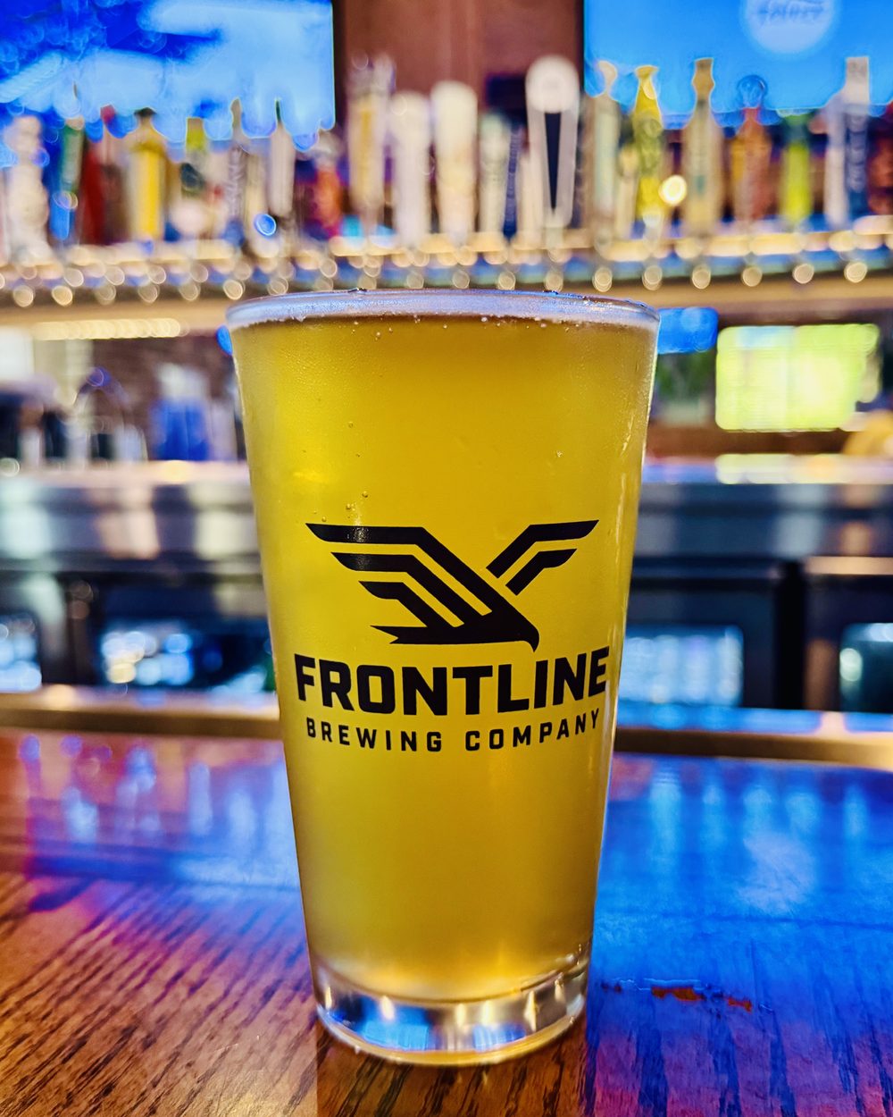A fresh pint of Frontline American Lager on the bar