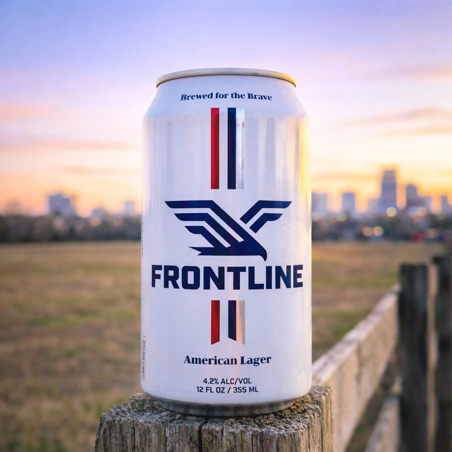 A can of Frontline American Lager on a fence post at sunset