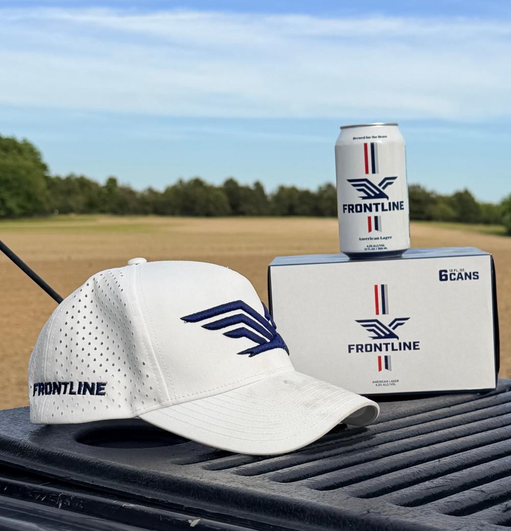 A white Frontline hat beside a can and six-pack on a truck tailgate